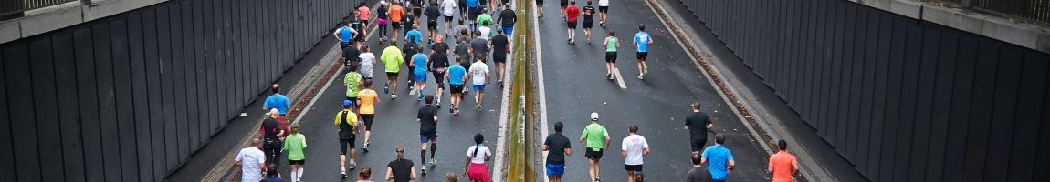 Large group of adults running a road race