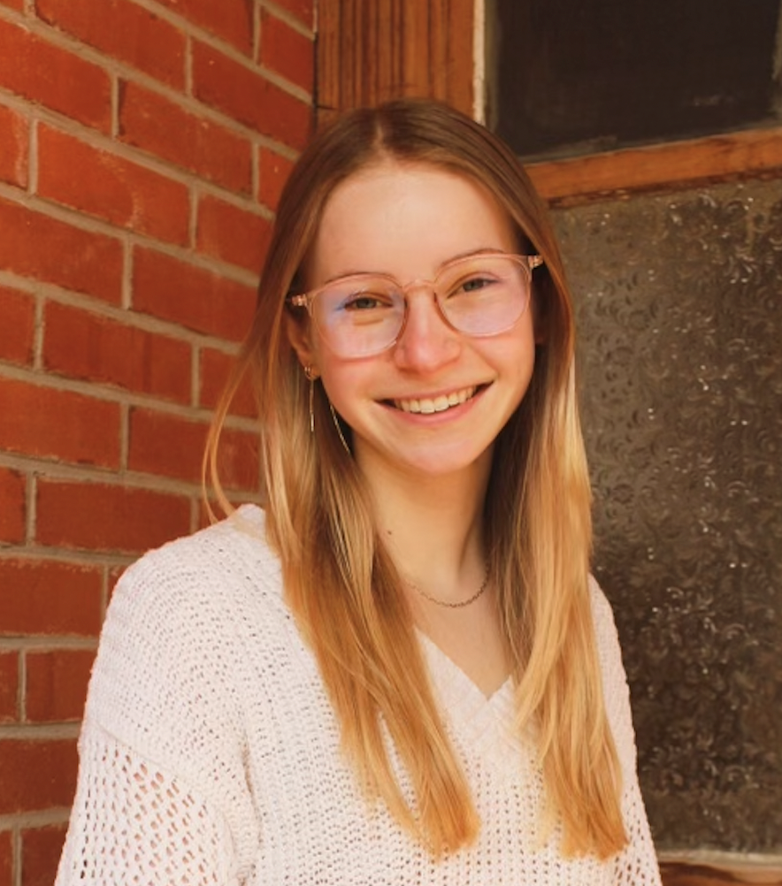 Headshot of Claire Lipton in front of a red brick wall.