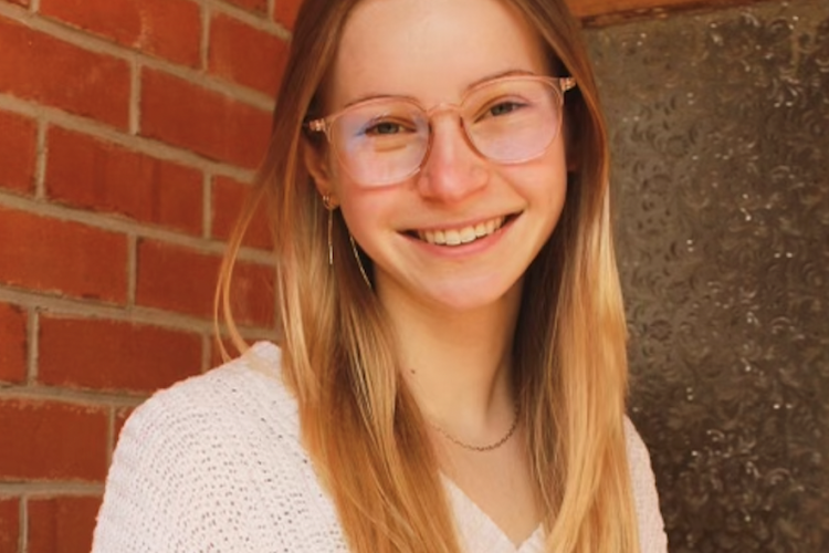 Headshot of Claire Lipton in front of a red brick wall.